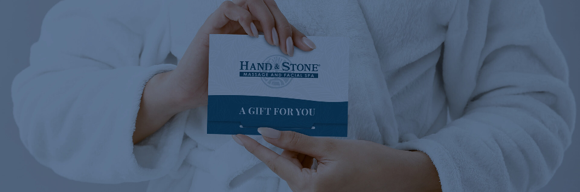 A Hand & Stone gift card envelope with elegant floral motifs and the text A Gift For You